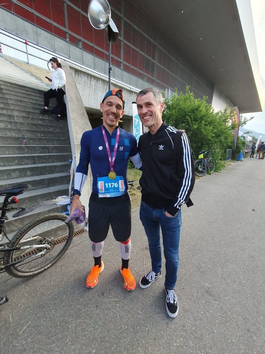 Dominik Erne with his finisher medal next to Reto and his bike