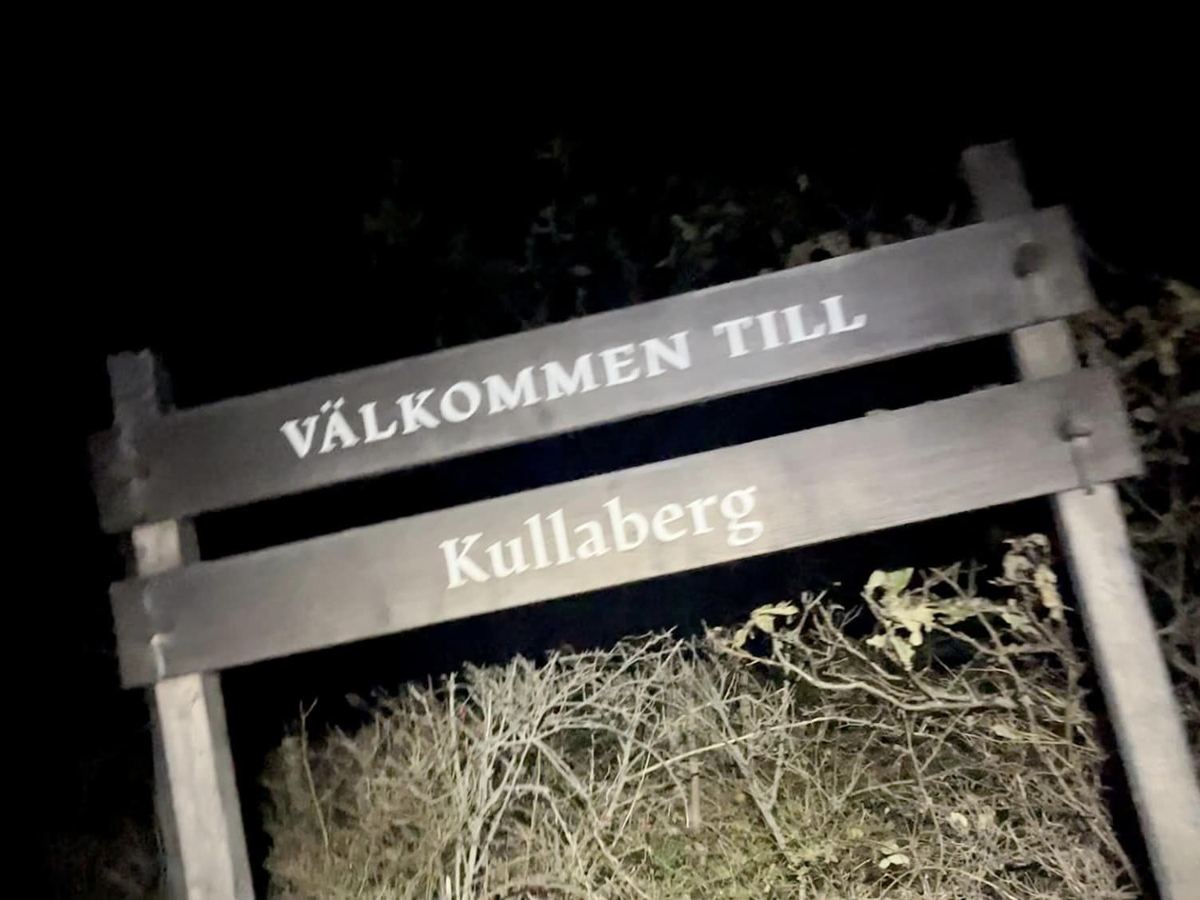 The Välkommen till Kullaberg sign at night
