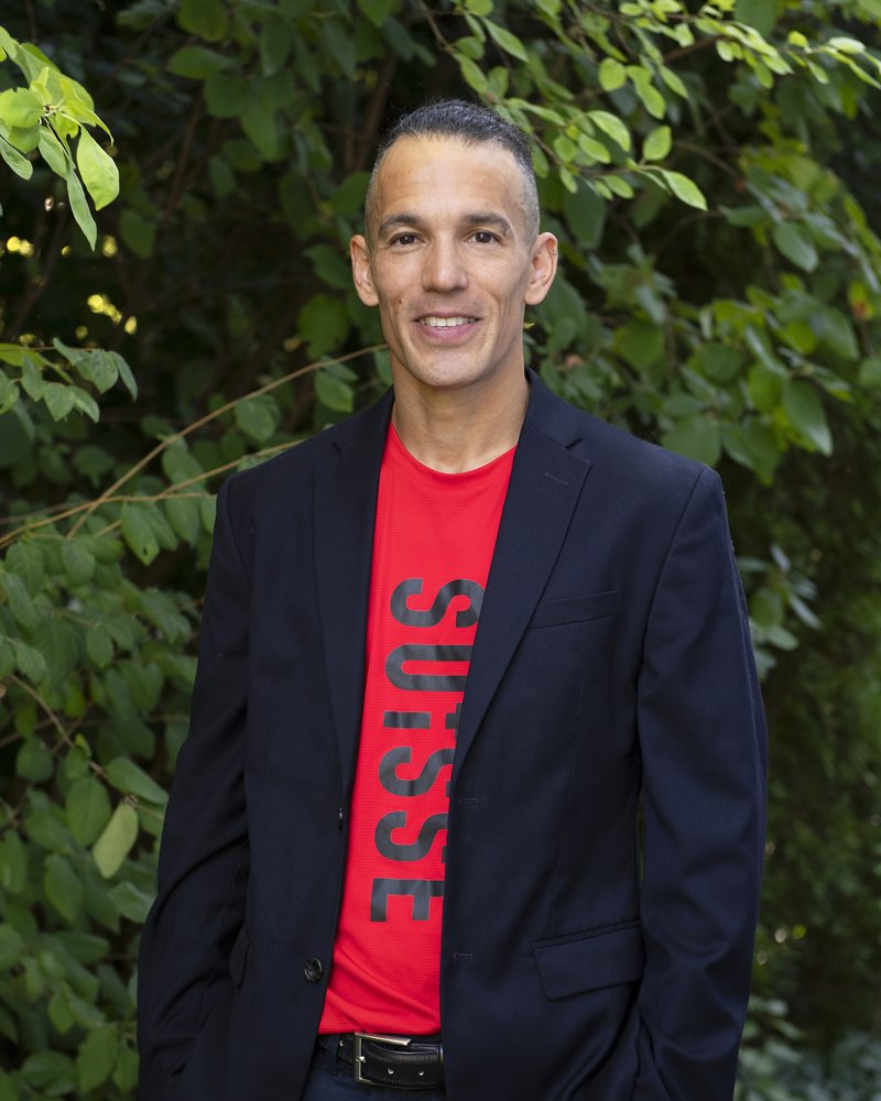 Dominik Erne, portrait in a blazer over the Swiss national team shirt