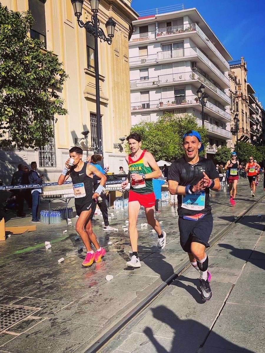 Marathon runners passing historic buildings in Sevilla