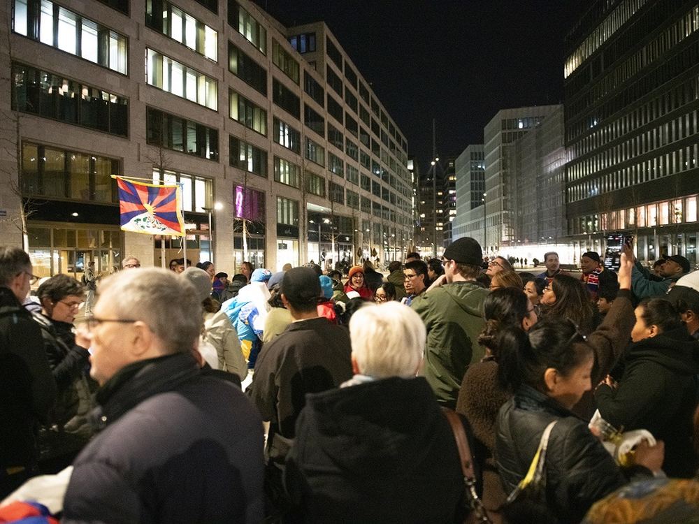 A crowd with Tibetan flags in Zurich at night