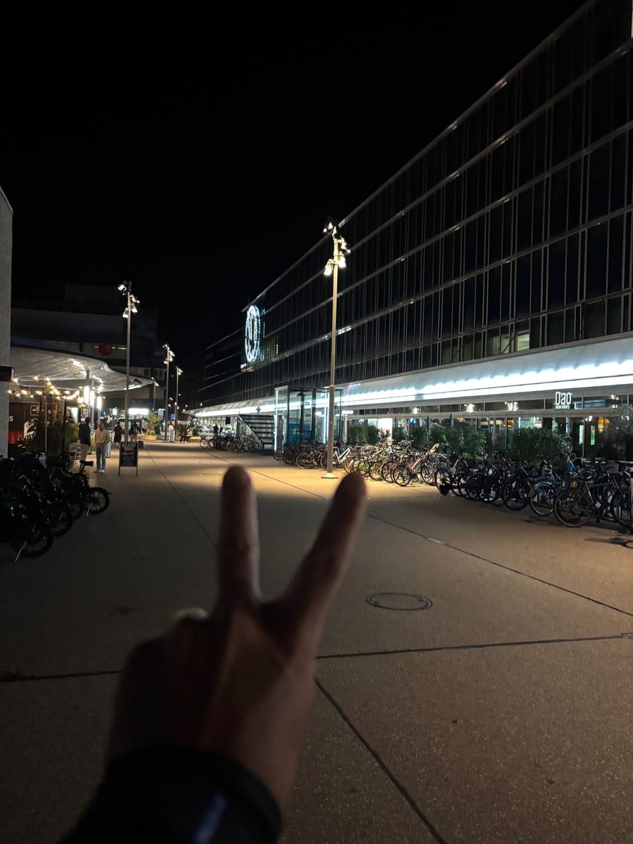 A peace sign in front of a station at night