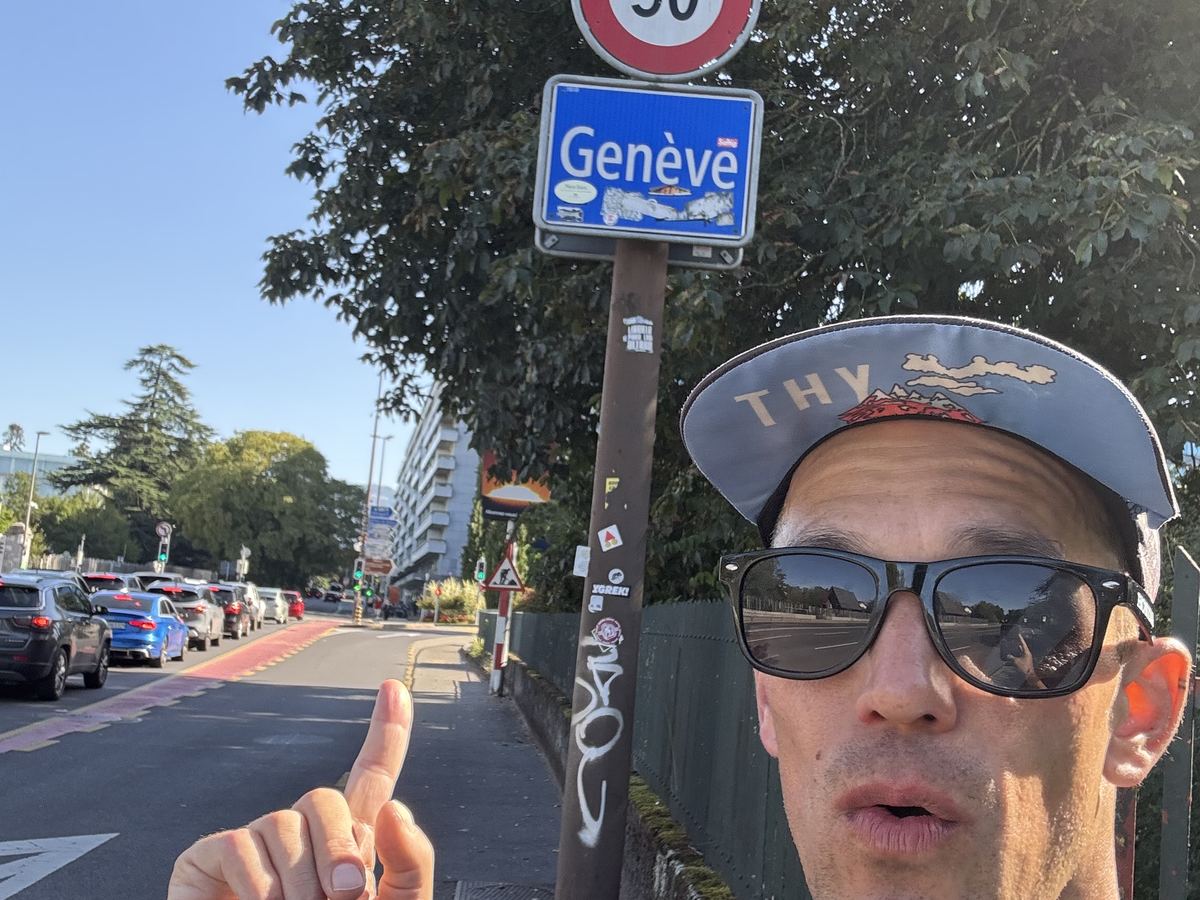 Dominik Erne pointing at the Genève road sign