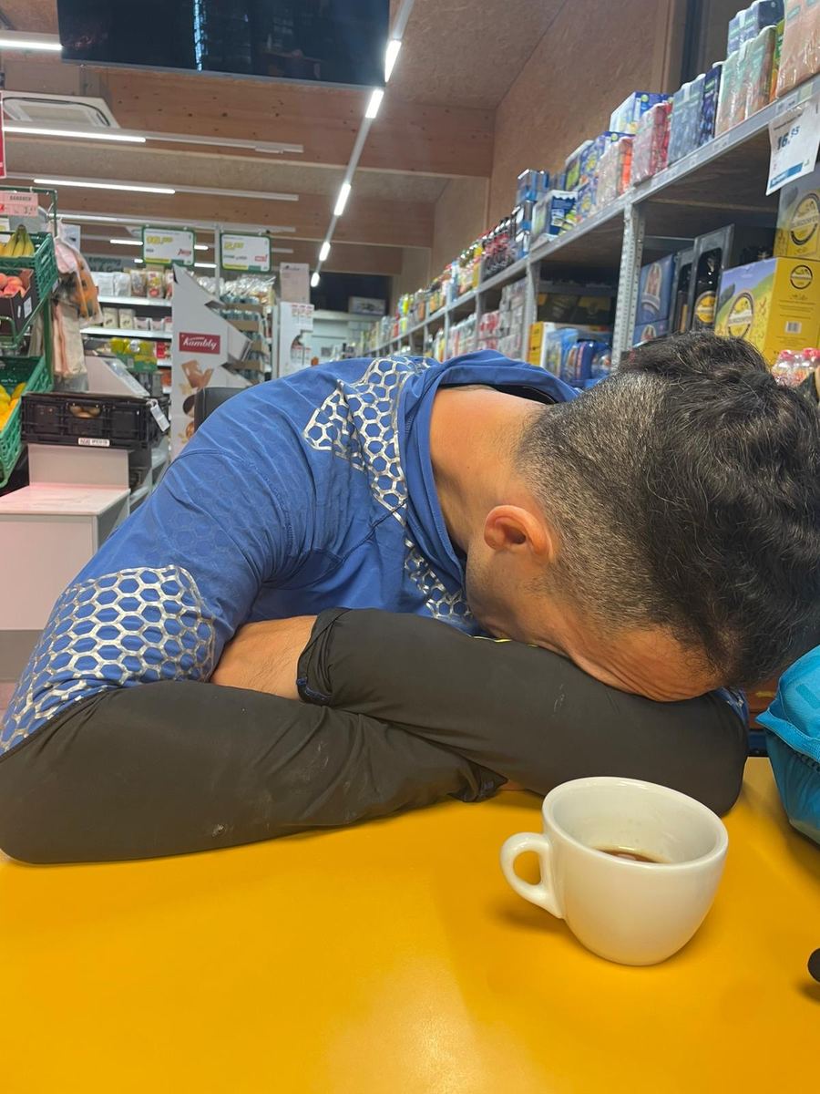Dominik Erne asleep with his head on a table next to a coffee cup